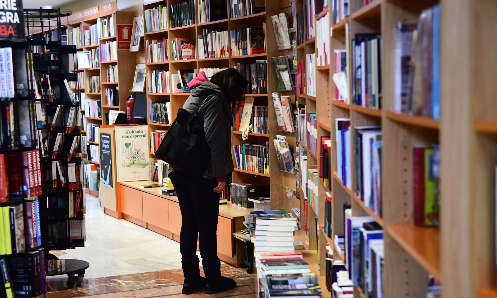 Una mujer mira unos libros en una librería de Córdoba.