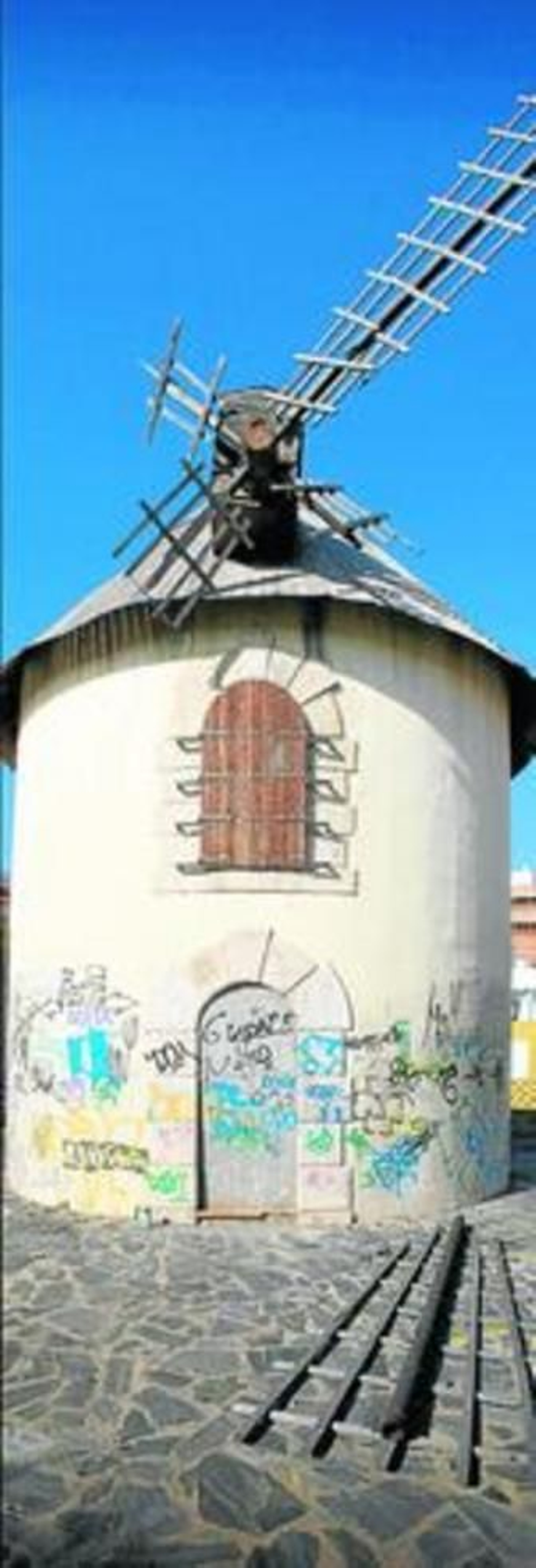 Puerta tapiada y pintadas en la fachada del Molino de los Díaz.