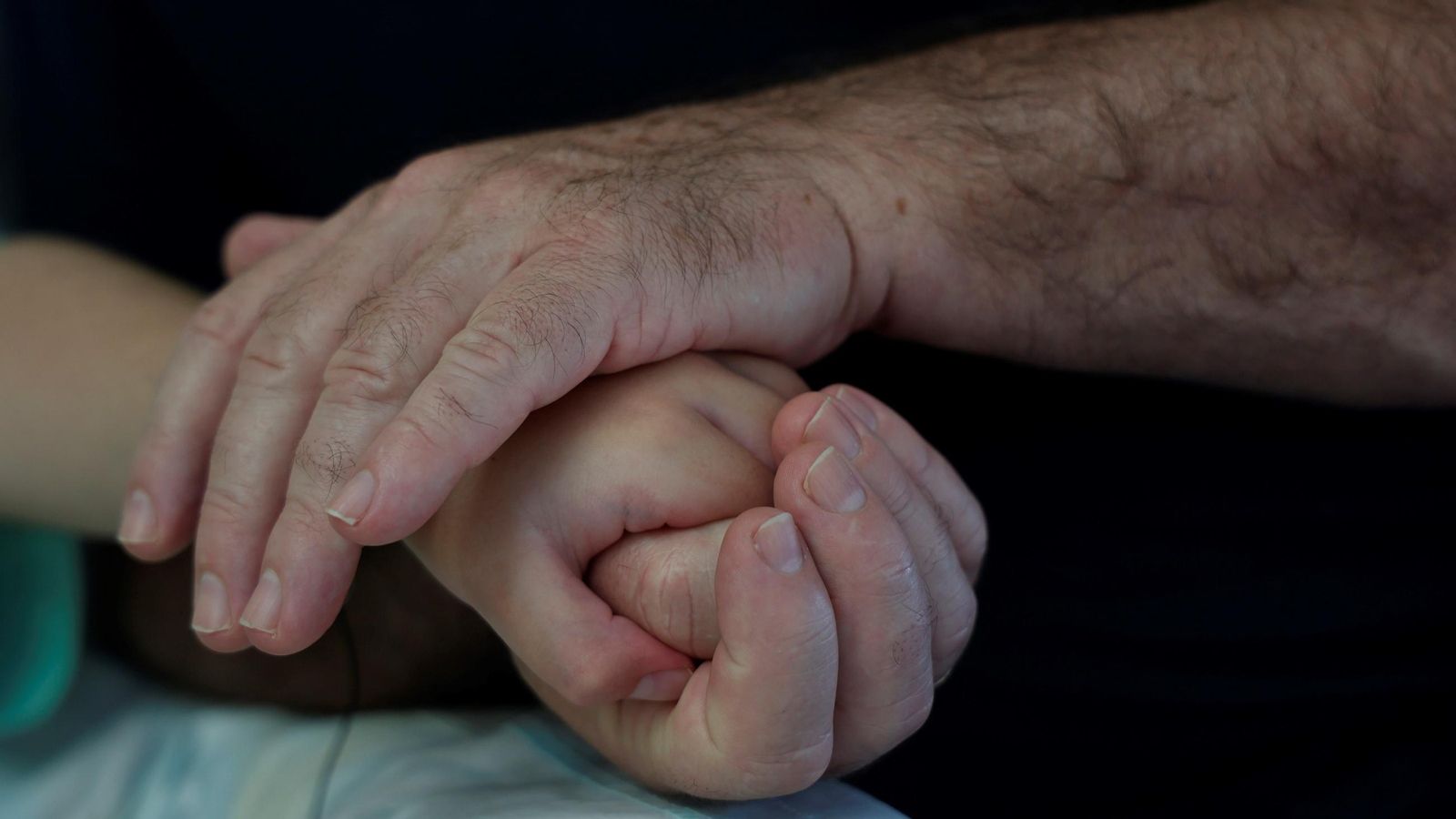 El padre de Juan coge con cariño su mano. El padre de Juan coge con cariño su mano.