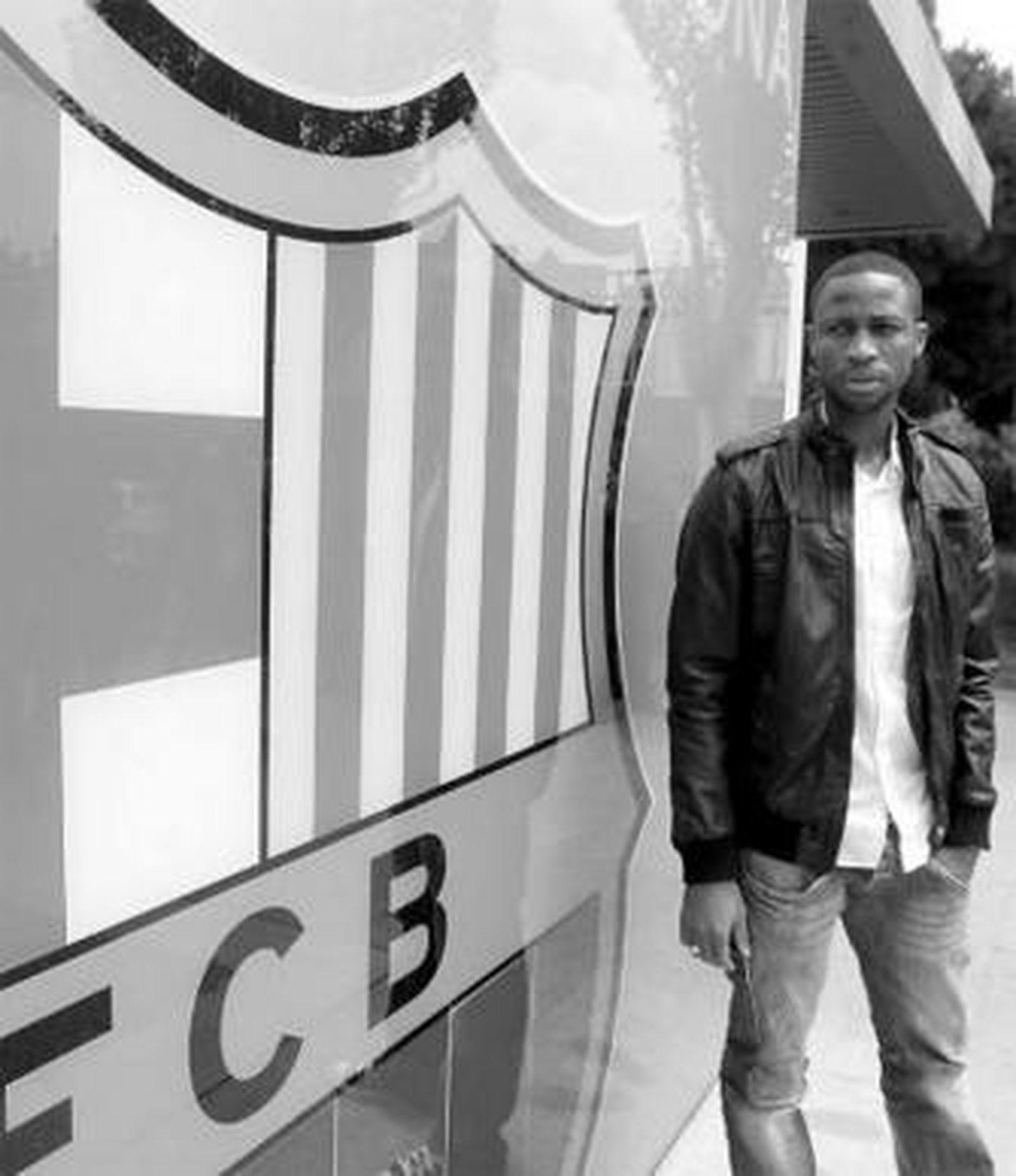 El nuevo jugador del Barcelona posa junto al escudo del club.