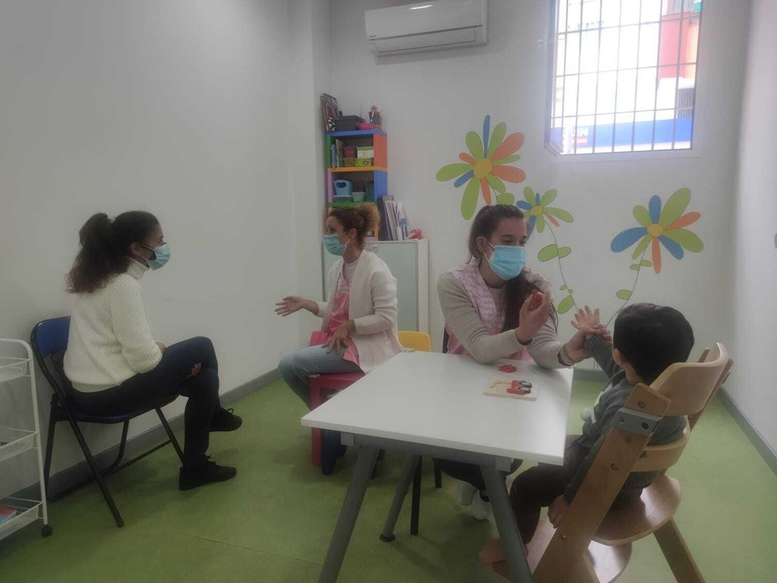 Logopeda y fisioterapeuta trabajando con una familia.