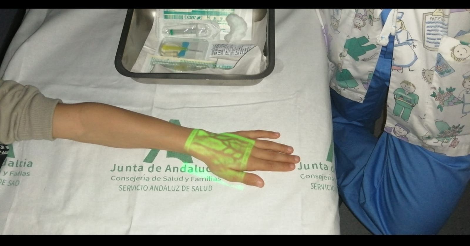 La luz infrarroja que emite el dispositivo sobre la mano de un menor.