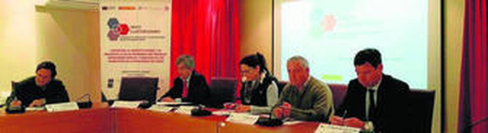 Imagen de la reunión técnica para hablar del clúster del queso, con el cartel en el que se lee 'Crece clusterizando'.