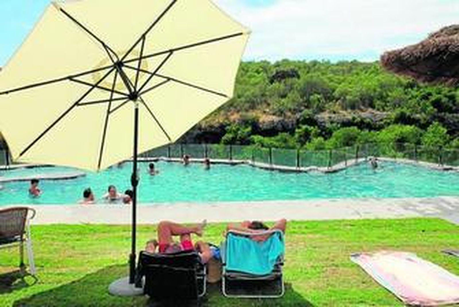 Bañistas en la zona de la piscina, donde se puede disfrutar del relax y el entorno rural de Hornachuelos.