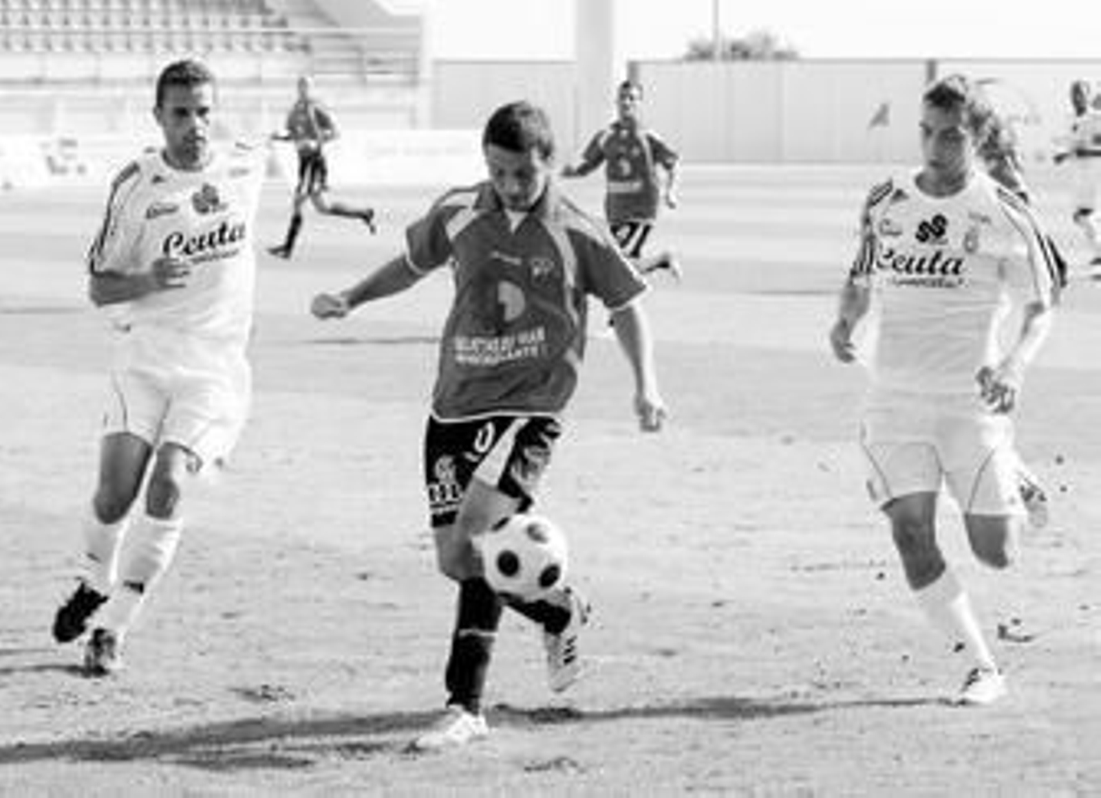 Xavi Molas controla un balón, ante la presencia del ex rojiblanco Alberto y de Juanfran.