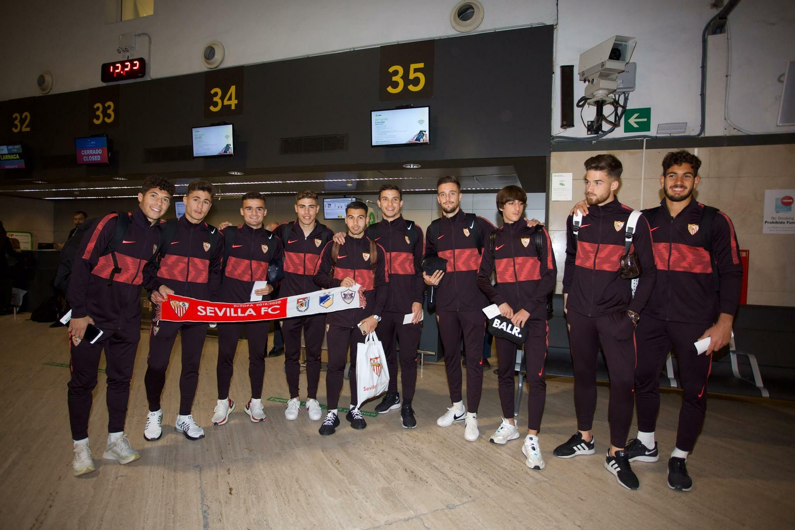 Los diez canterano que viajan con el Sevilla a Chipre posan en el aeropuerto.