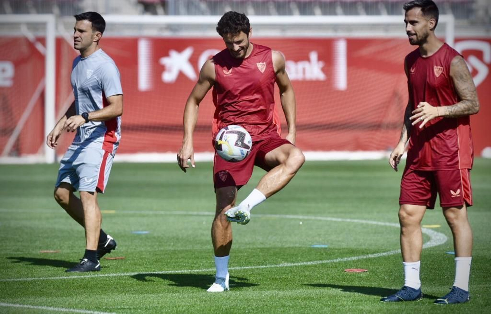 Suso sonríe ante Delaney y el preparador físico Óscar Caro.