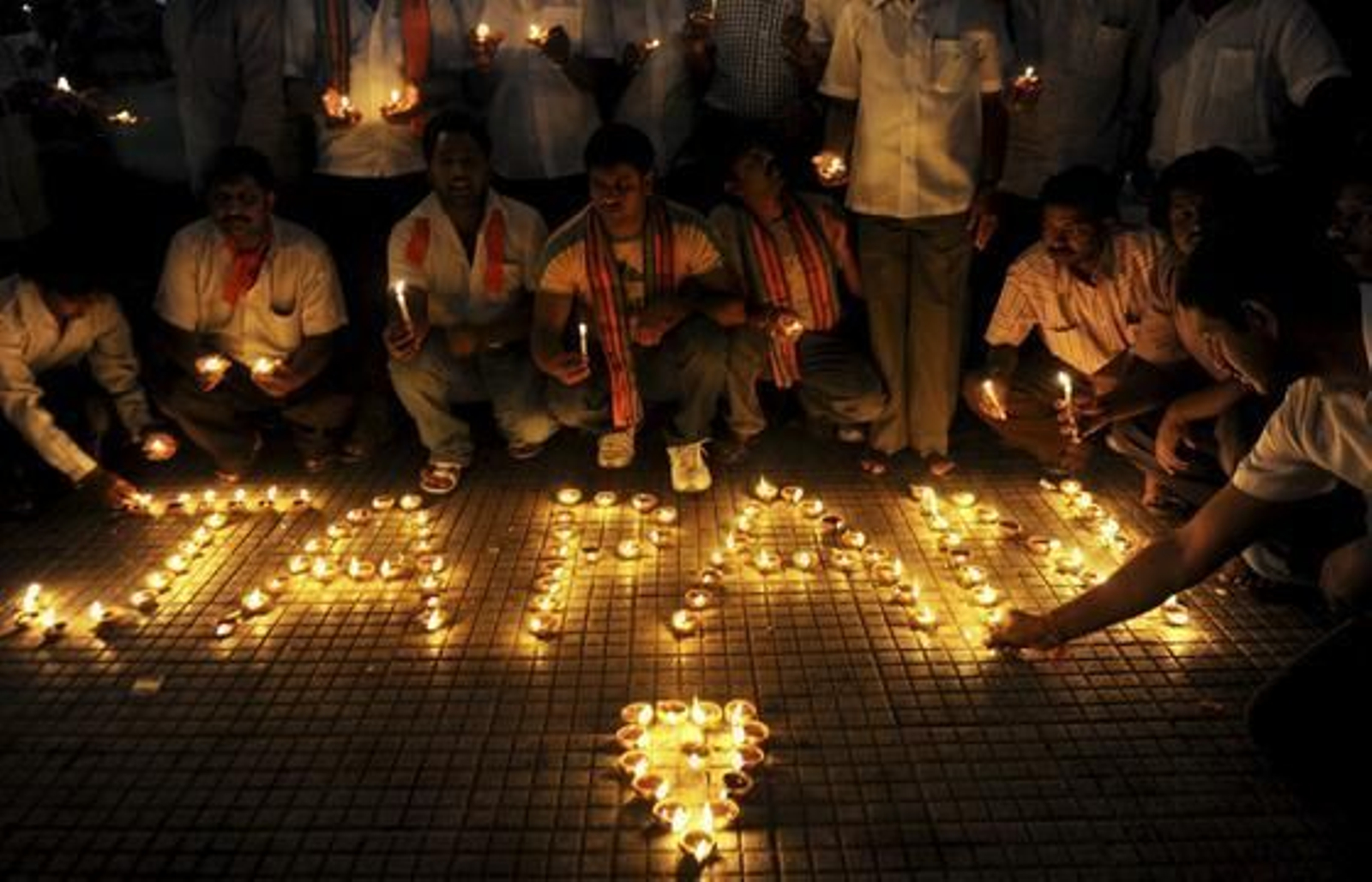 Políticos indios encienden velas en homenaje a las víctimas fallecidas en el tsunami de Japón.