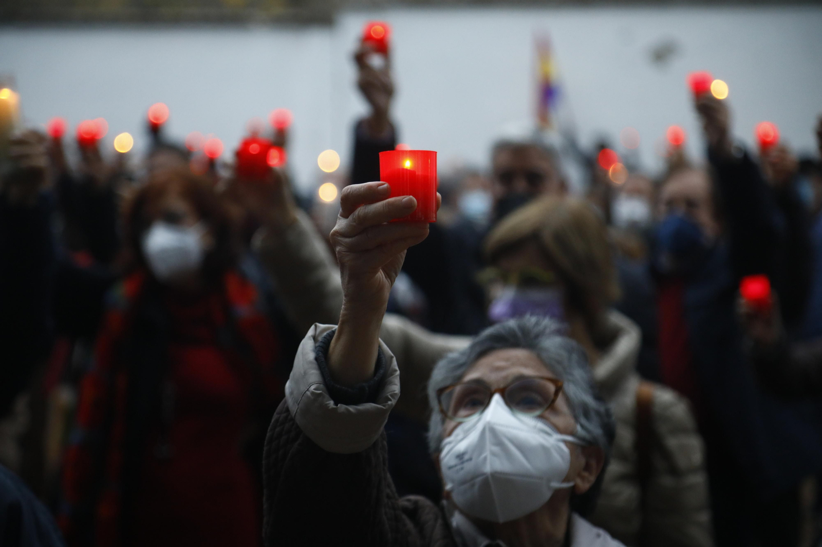 Los asistentes al cementerio recuerdan a las víctimas alzando las velas encendidas.