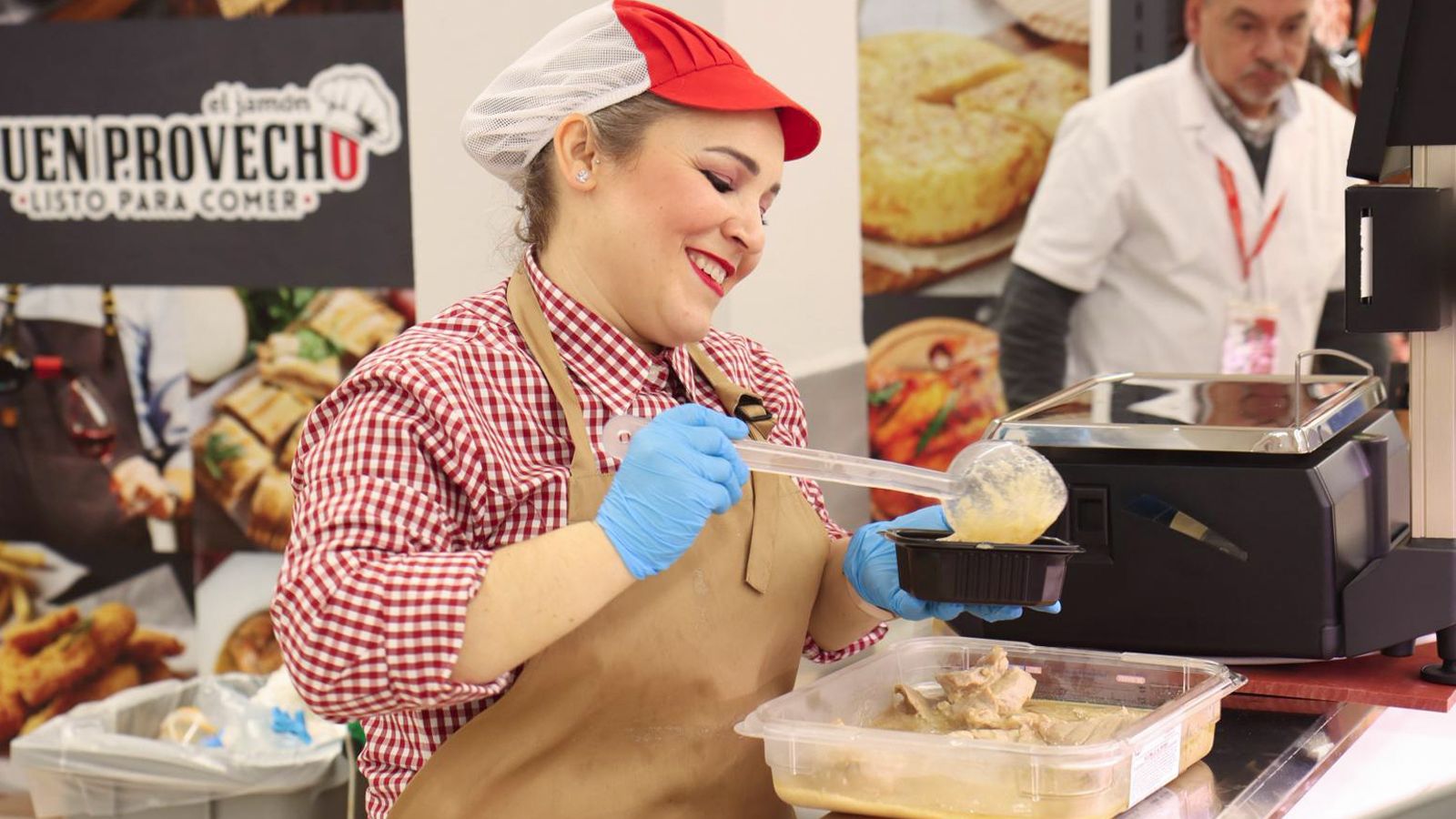 Una empleada prepara un plato para llevar.