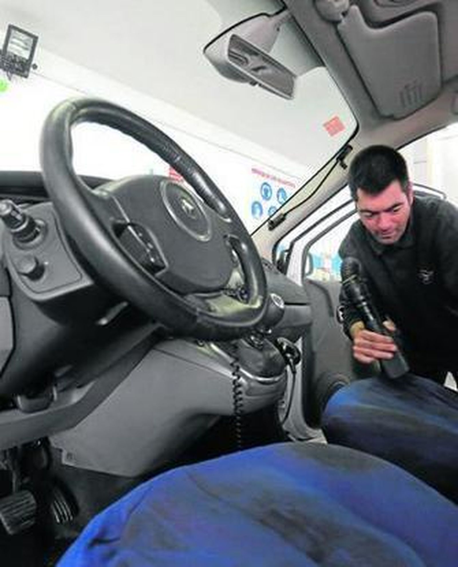 Un trabajador de Aspromanis Servicios limpia un coche, en las instalaciones de este centro.