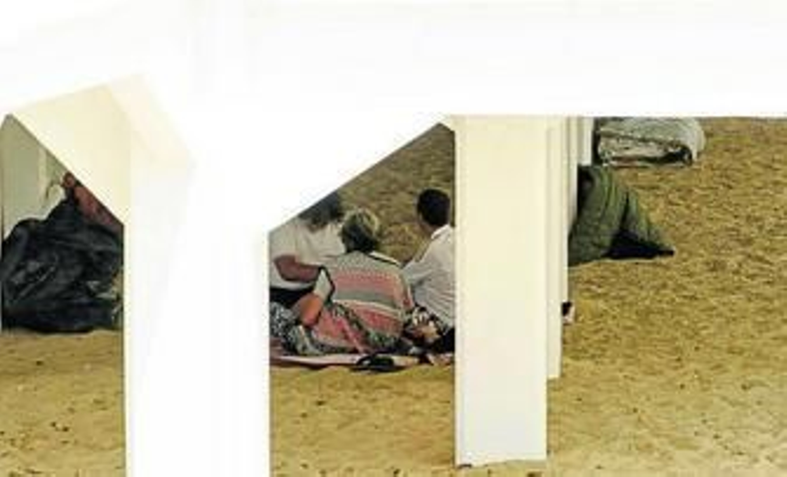 Algunos sin techo pasan el día en los bajos del balneario de La Palma en la playa de La Caleta.