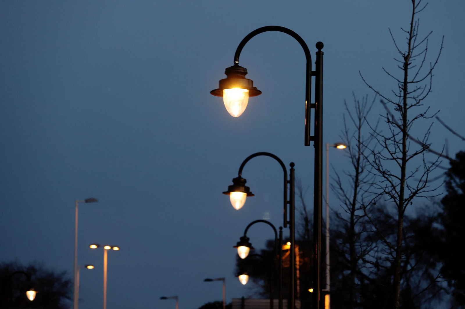 Una fila de farolas públicas encendidas. Una fila de farolas públicas encendidas.