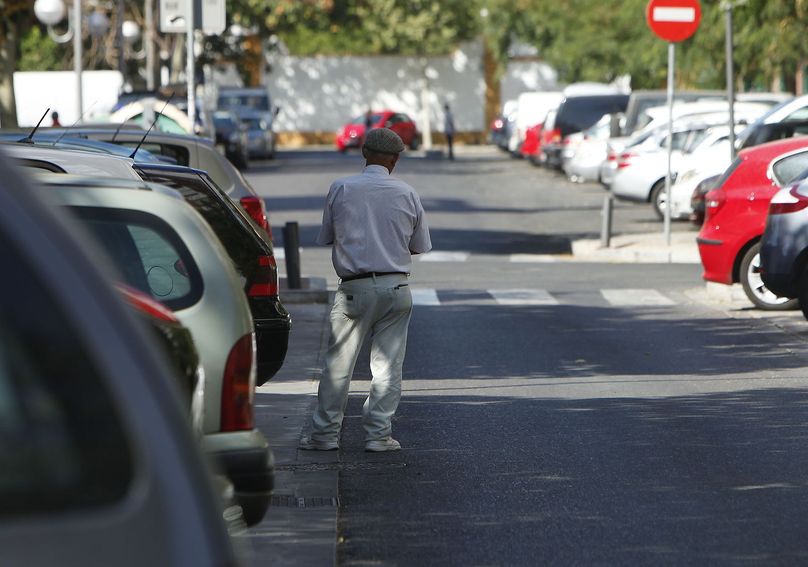 Un aparcacoches ilegal en una zona de aparcamientos de Sevilla.
