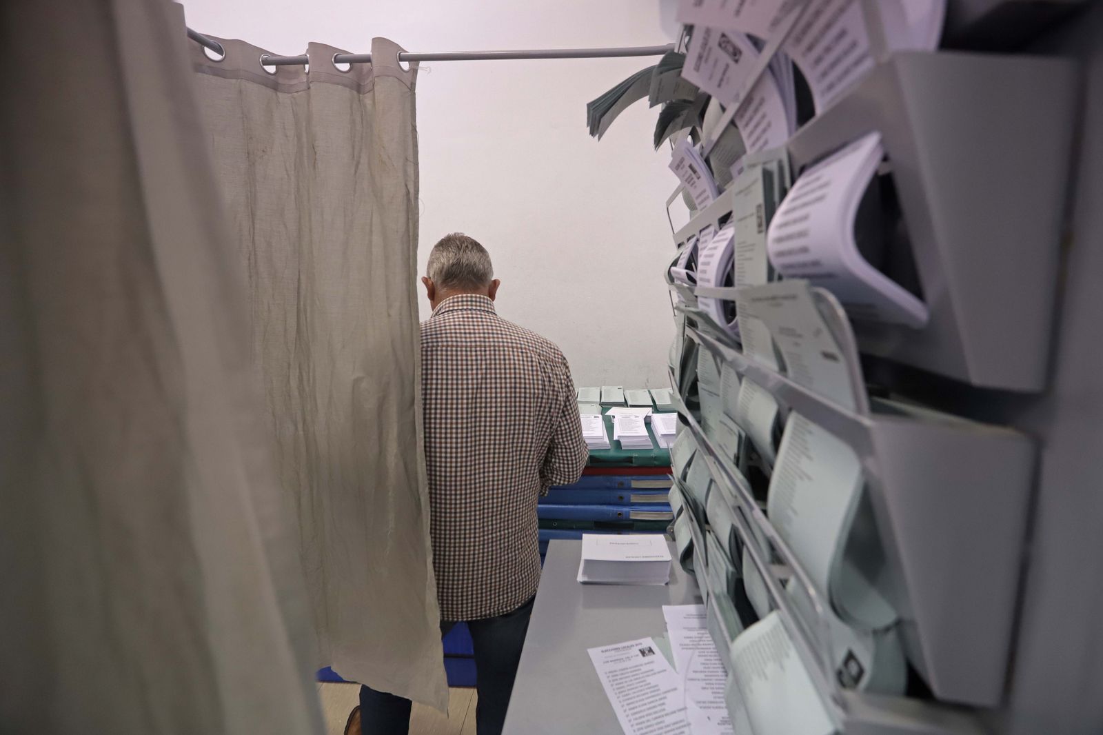 Un hombre busca entre las papeletas de un colegio electoral, en 2019.