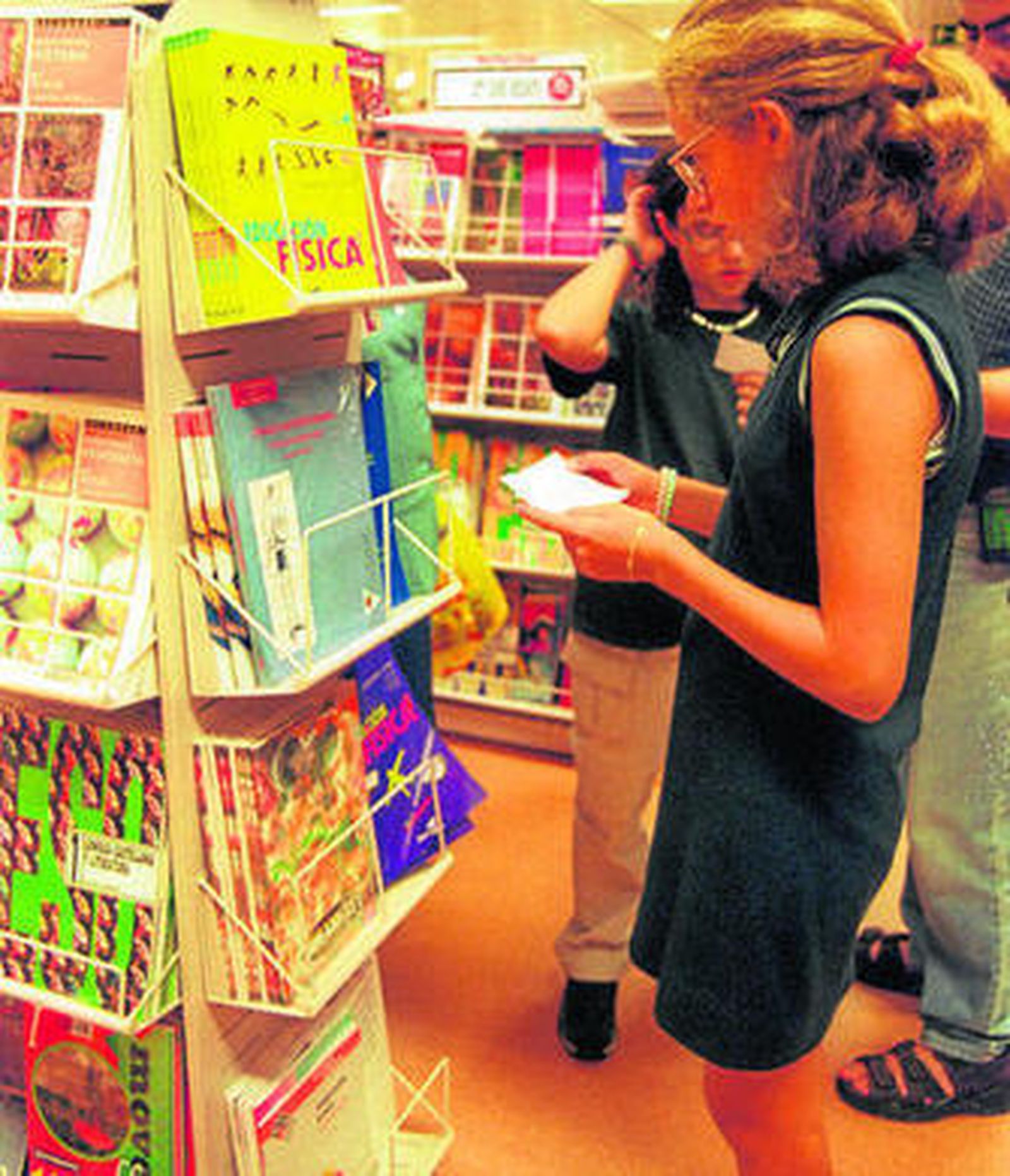 Una madre busca el material escolar en una papelería.