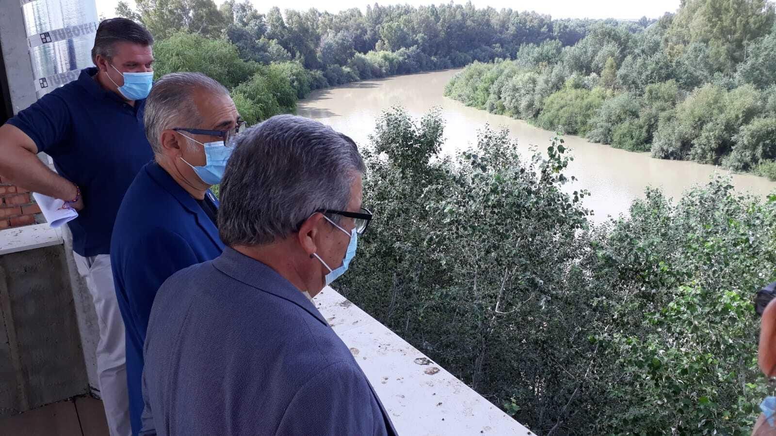 El subdelegado del Gobierno en Sevilla, Carlos Toscano, el presidente de la Confederación Hidrográfica del Guadalquivir (CHG), Joaquín Páez Landa, y el alcalde de Alcolea del Río, Carlos López Barrera, avistan el río desde el futuro Centro de Interpretación.