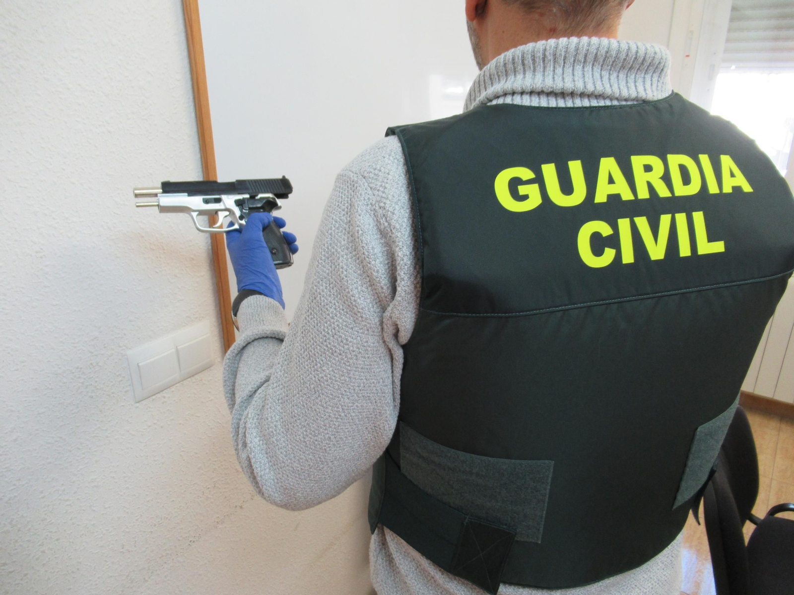 Un agente con la pistola intervenida