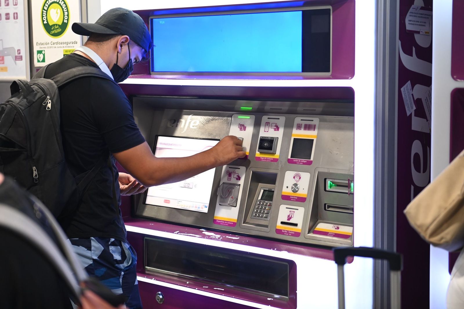 Un cliente manipula una de las máquinas expendedoras de billetes y abonos.