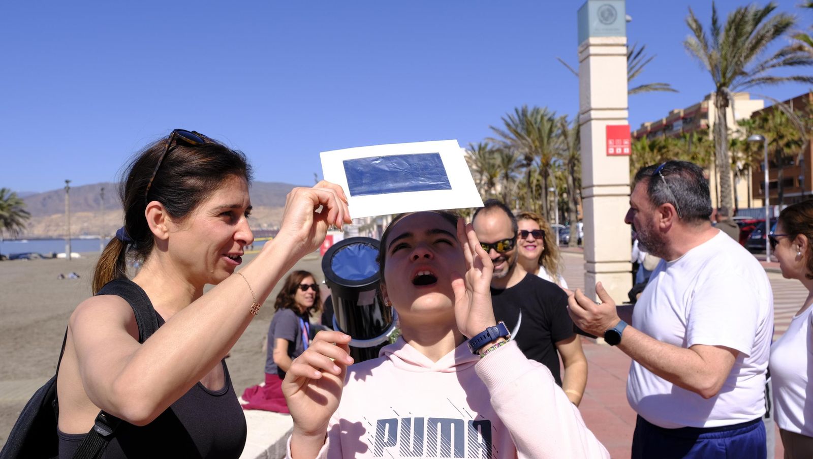 Almería observa el eclipse solar desde el Paseo Marítimo, en imágenes