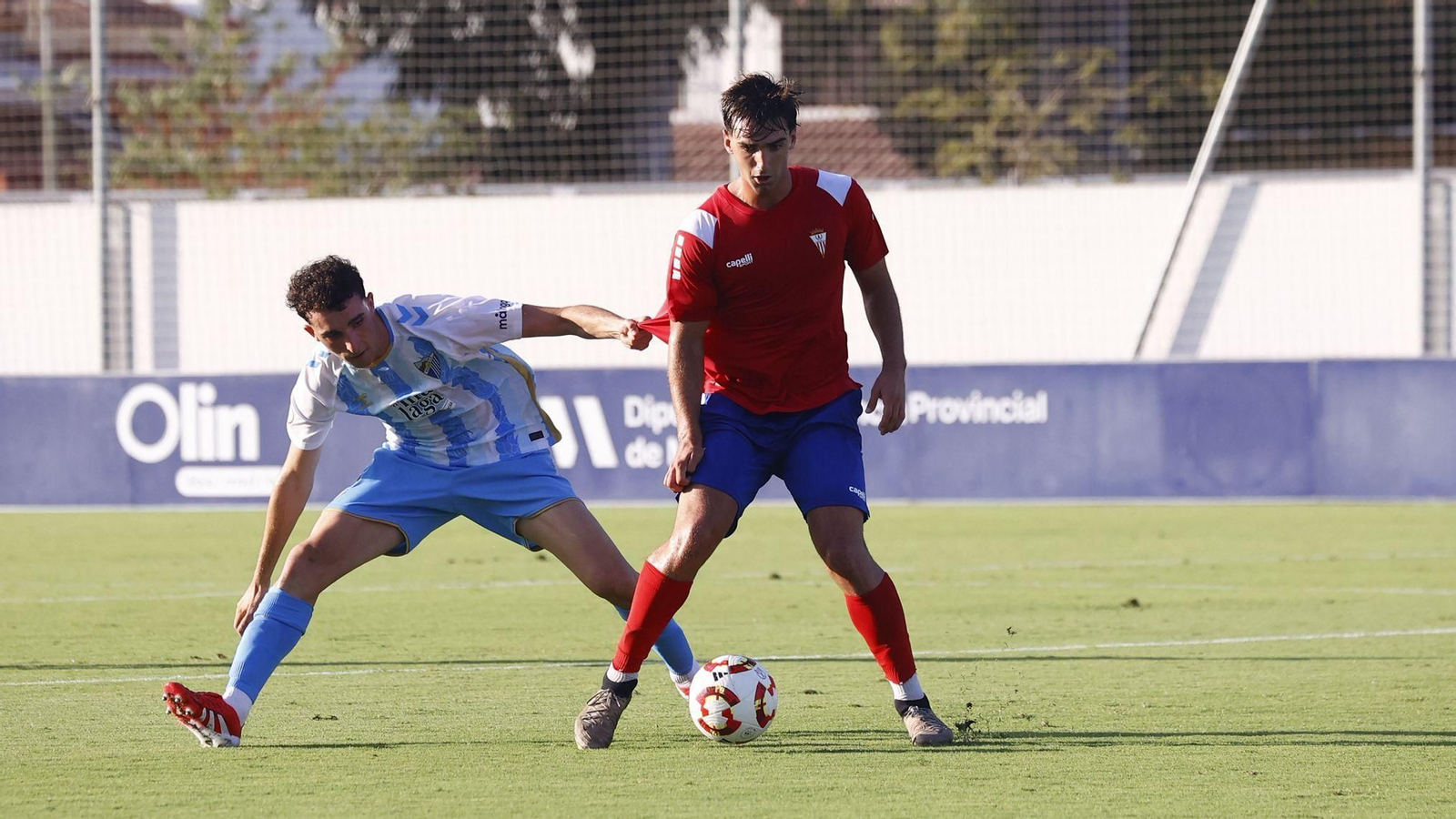 El algecirista Manín, agarrado por un jugador del Malagueño.