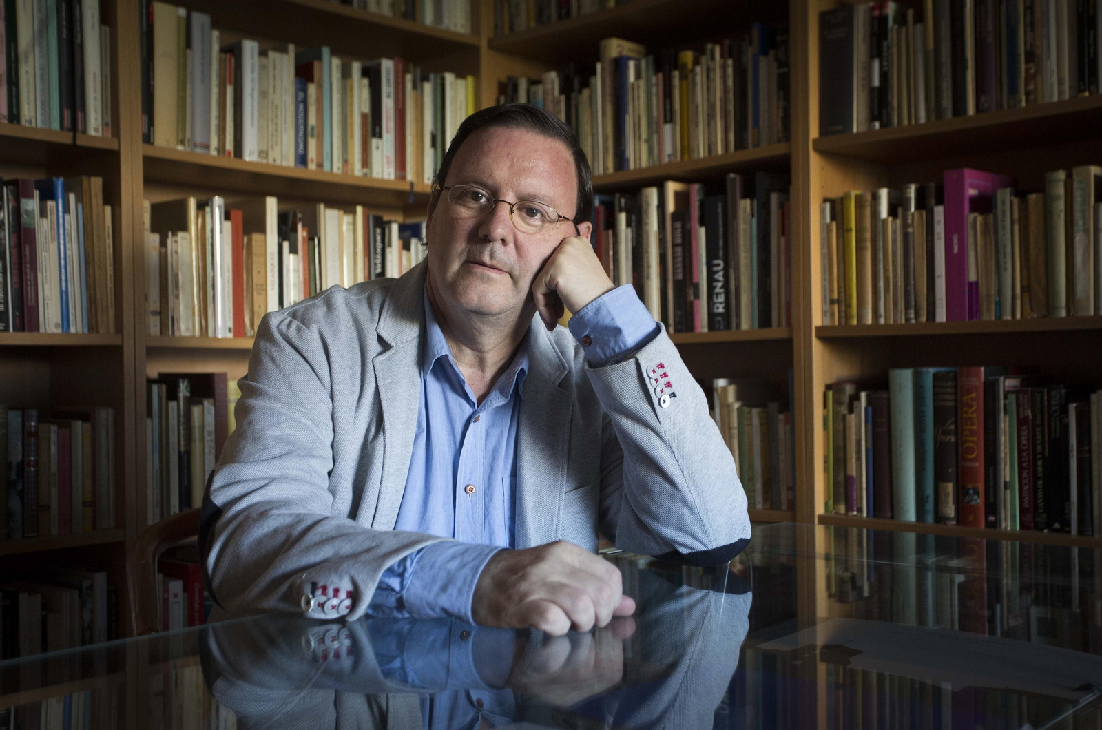 El poeta Juan Lamillar (Sevilla, 1957), retratado ante la biblioteca de su casa.