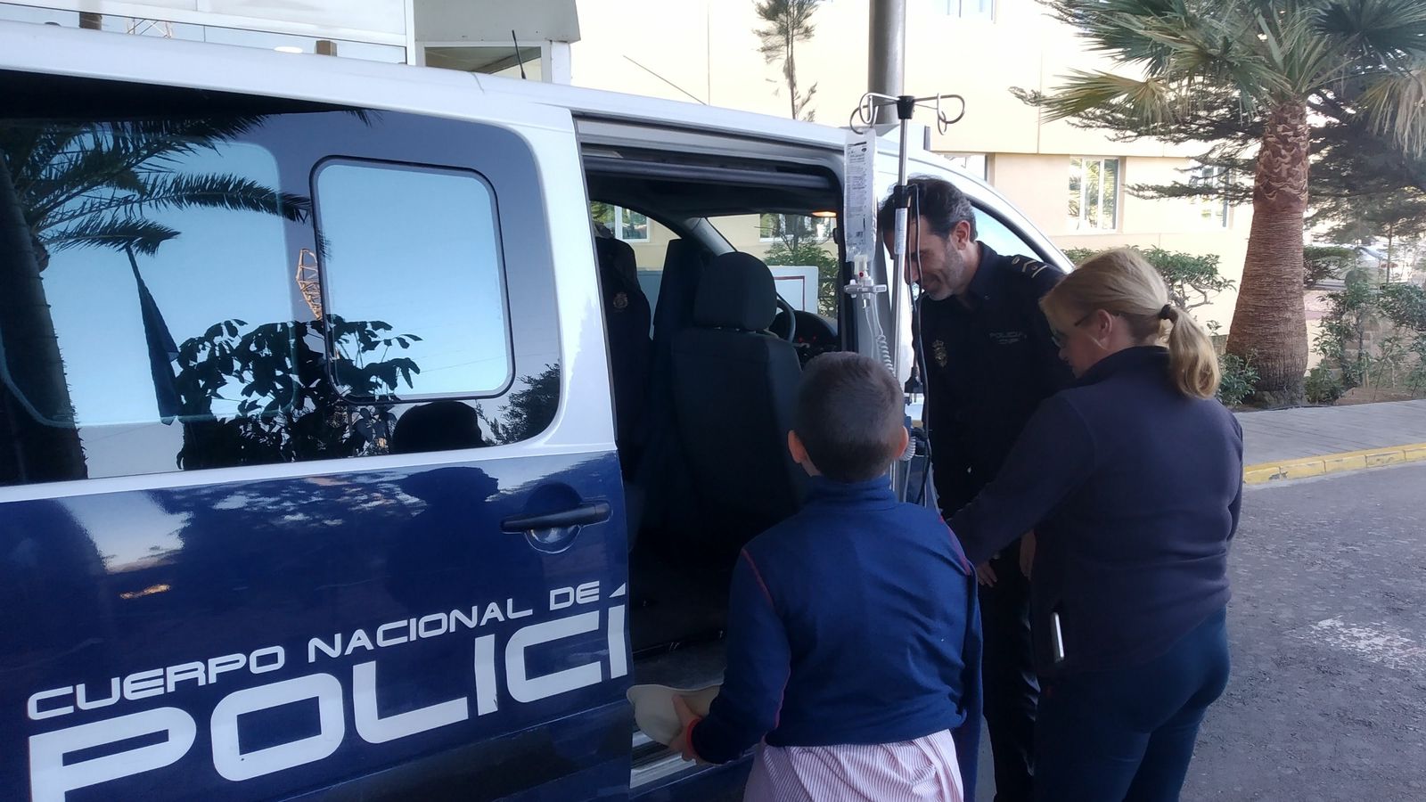 Uno de los pequeños ingresados en el Hospital accede al furgón de la Policía Nacional.