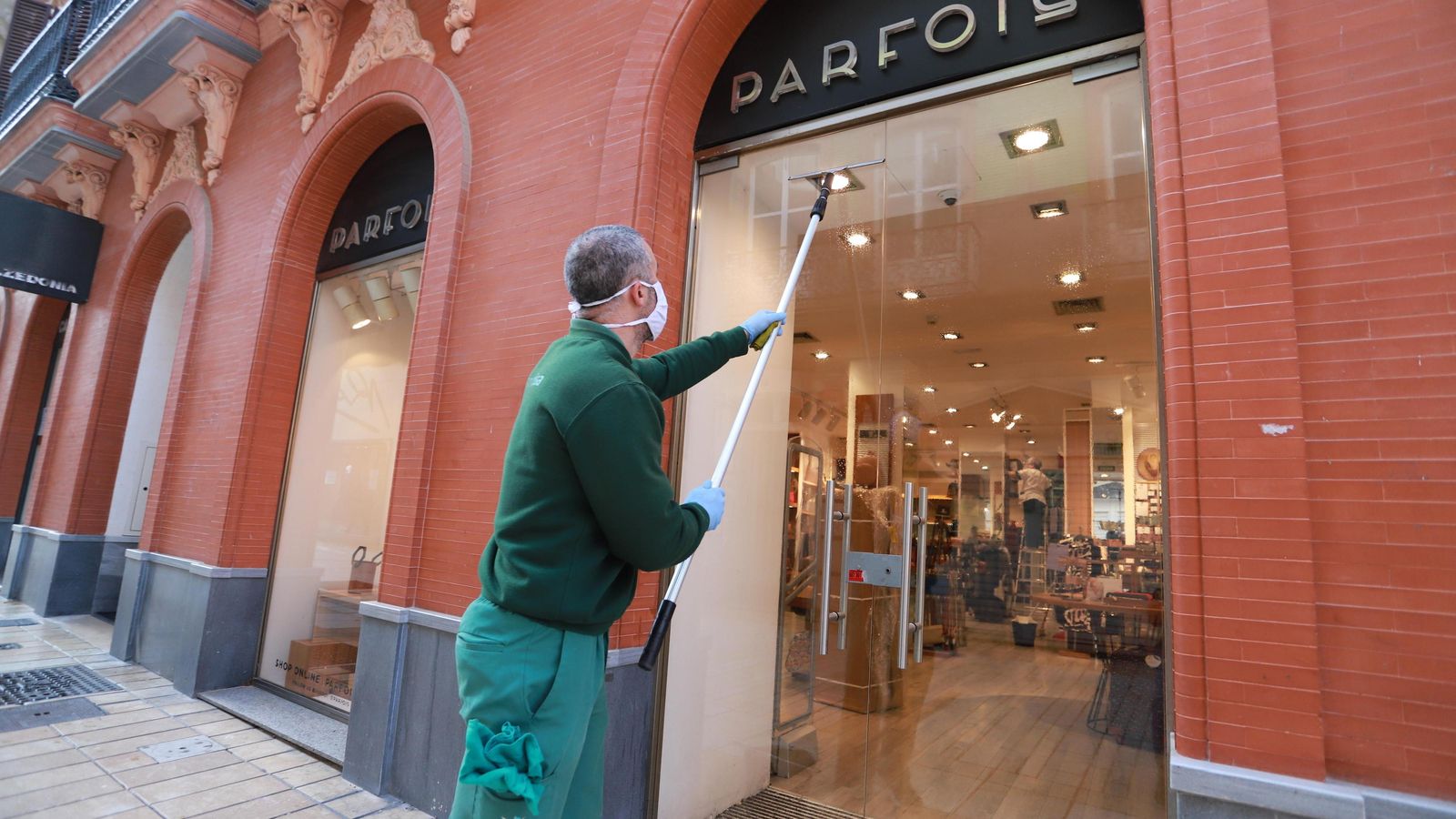 Un operario realiza labores de limpieza en un comercio.