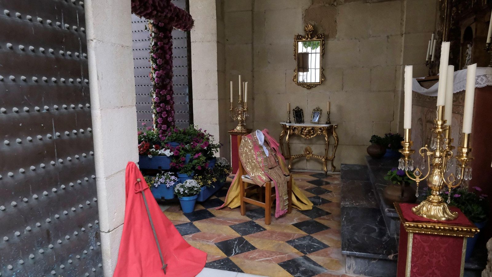 Parte trasera de la Cruz, con el traje de luces y demás elementos taurinos ante Nuestra Señora de Belén.