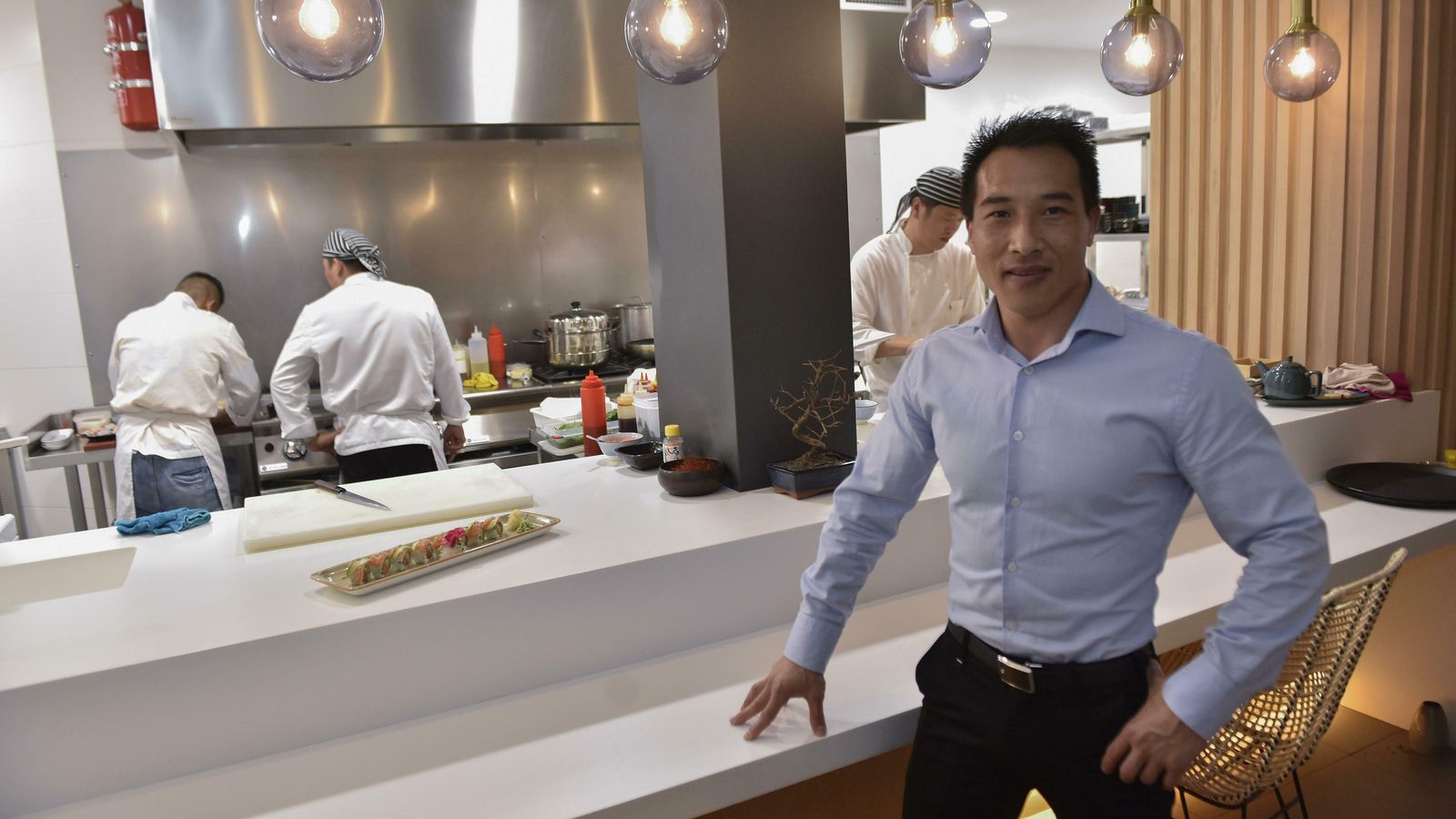 Fu Cheng Zhang, en su restaurante con la cocina al fondo.