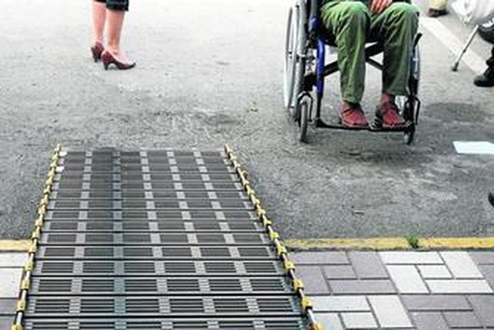 Una persona en silla de ruedas se dispone a subir una rampa de acceso a un vehículo.