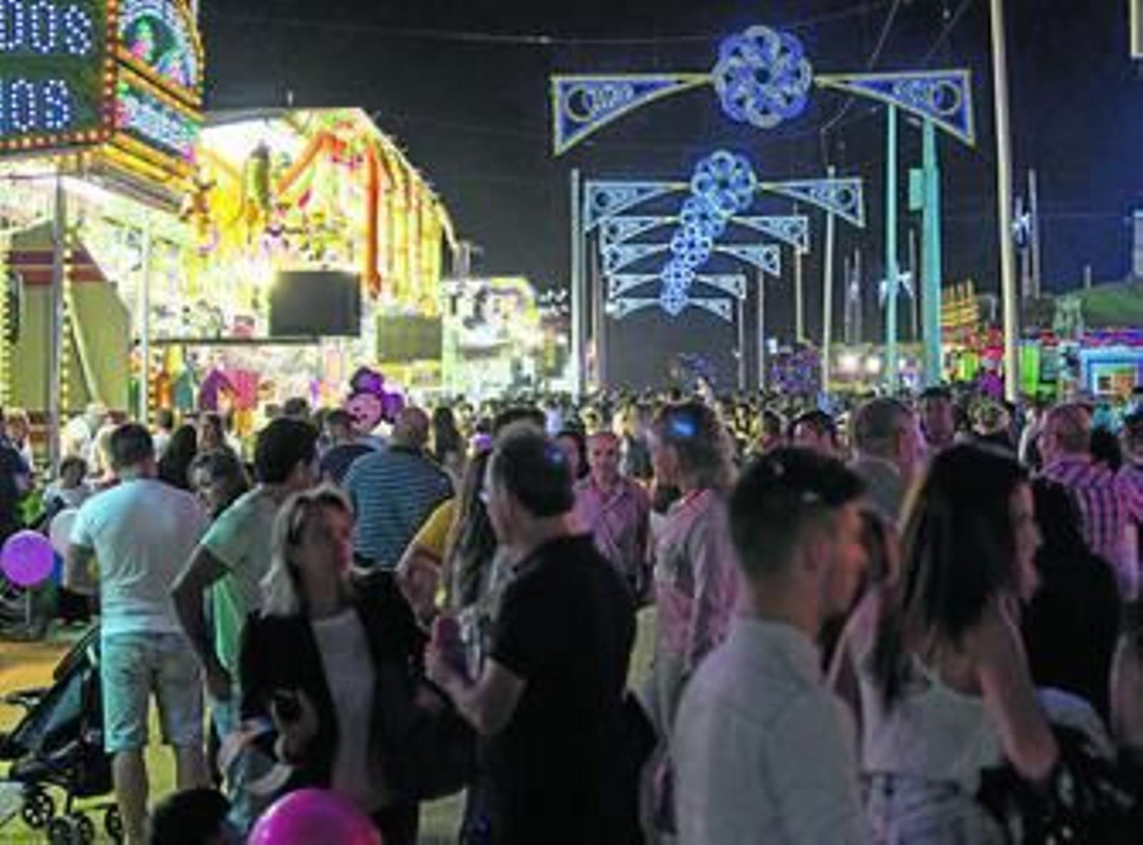 Viandantes paseando por una de las calles del recinto ferial en la noche de ayer.