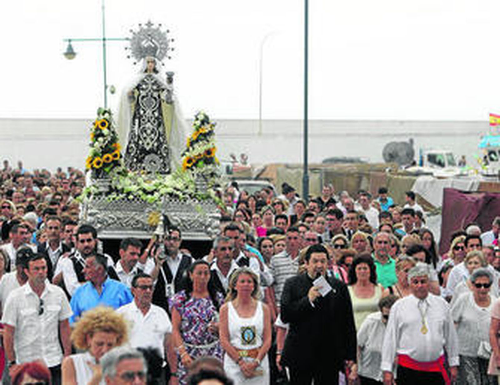 La alcaldesa de Marbella y el párroco de la iglesia acompañan a la Virgen en procesión.