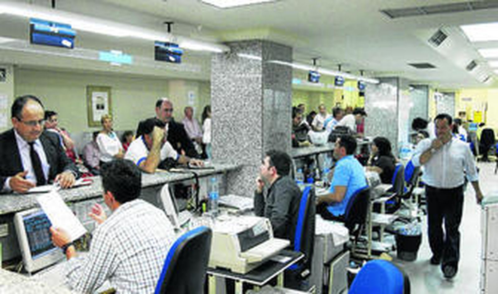 Varios funcionarios del Ayuntamiento de Málaga atienden a los ciudadanos.