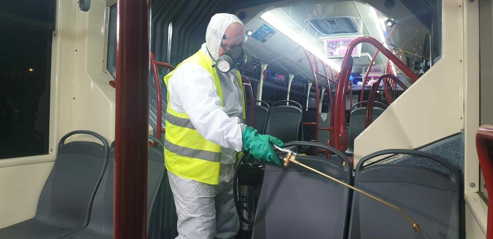 Un operario limpiando un autobús de Tussam.