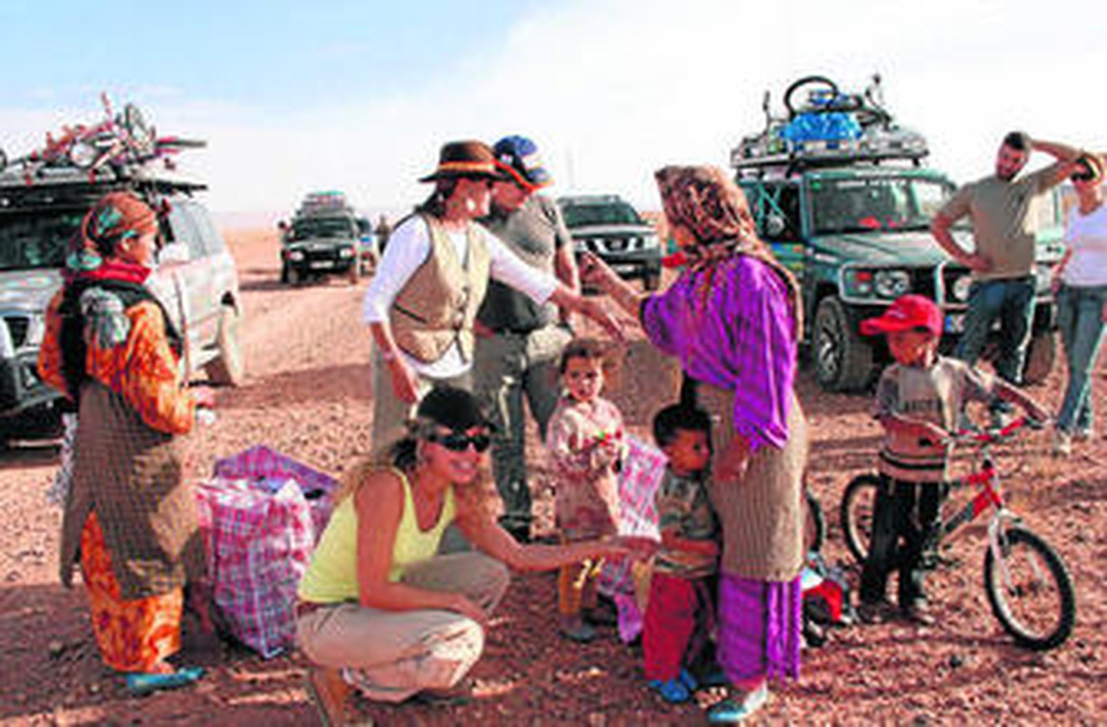Los expedicionarios entregan ropa y bicicletas a una familia en mitad del desierto.