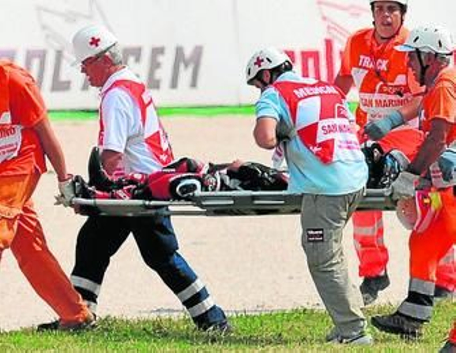 Los médicos del circuito se llevan a Tomizawa en camilla tras su fatídica caída.