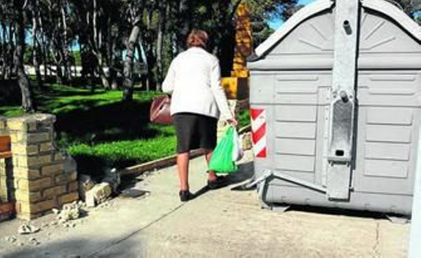 Una mujer pasa junto al contenedor instalado en la acera de la avenida de Fuentebtravía, junto a la barriada del Pilar.