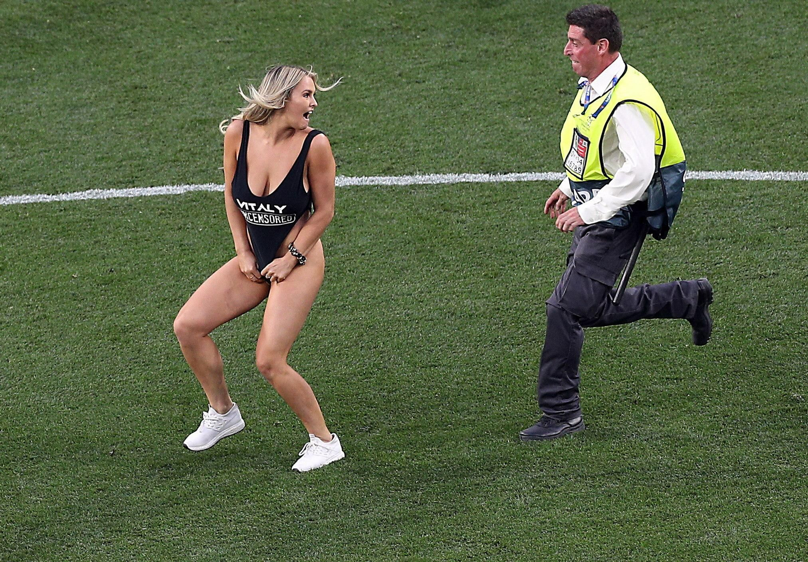 Un agente de seguridad de la UEFA persigue a la joven. Un agente de seguridad de la UEFA persigue a la joven.