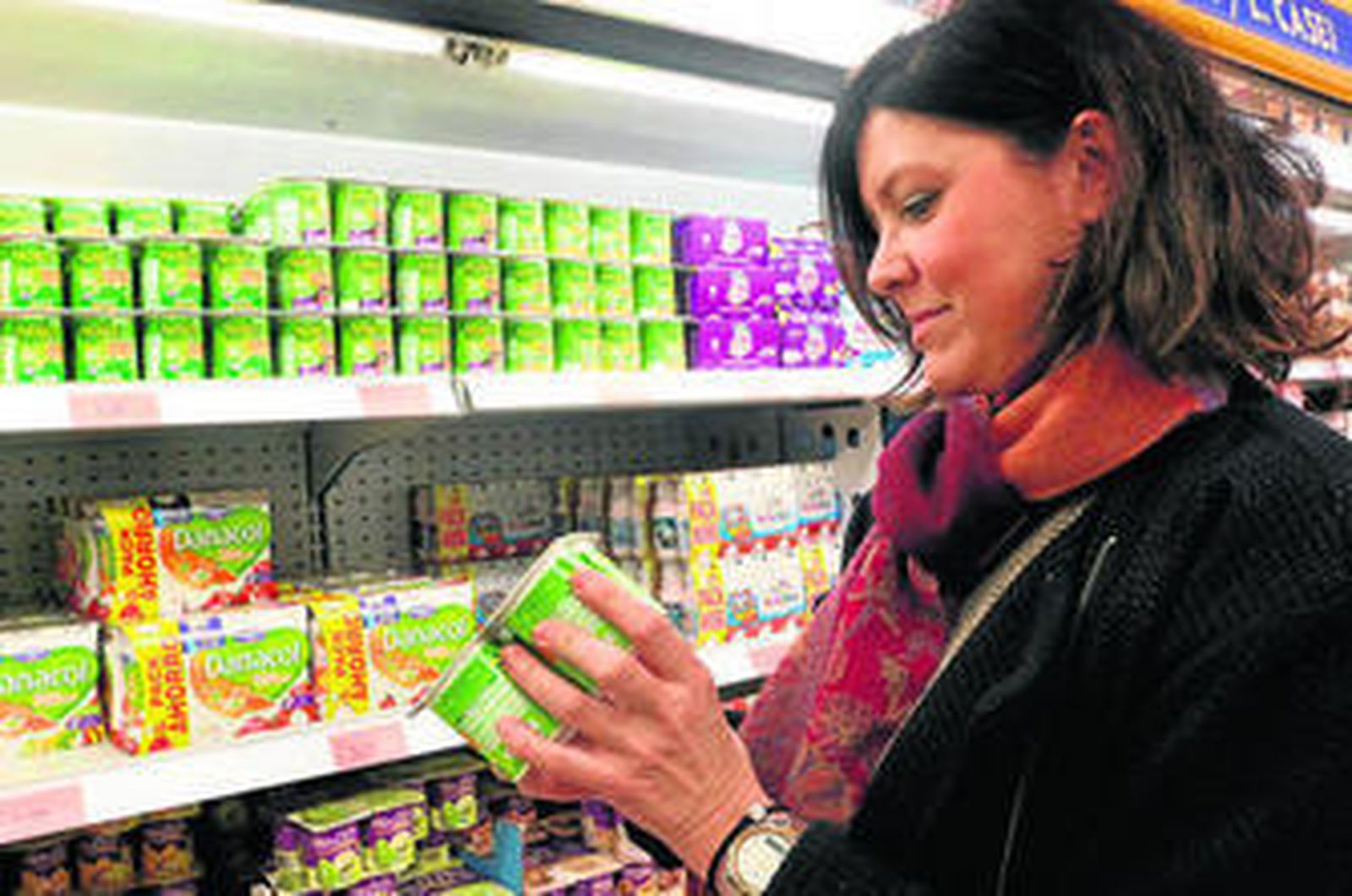 Una mujer mira la etiqueta de unos yogures de soja.