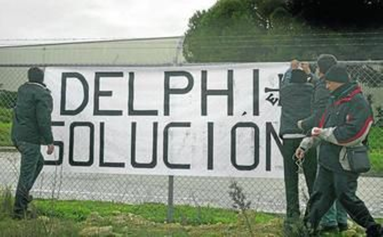 Los ex trabajadores de Delphi, colocando pancartas en la última protesta realizada esta misma semana.