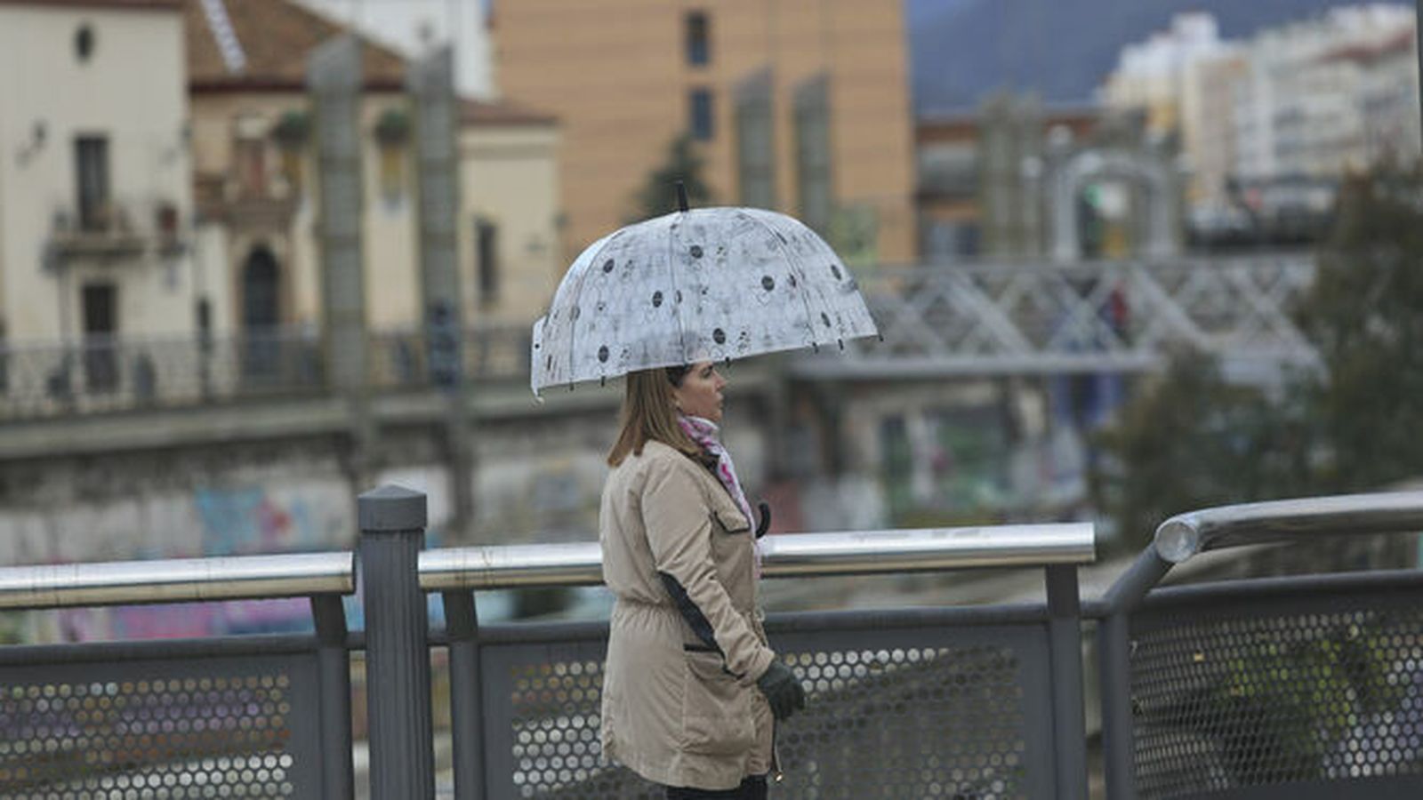 Una mujer se resguarda bajo su paraguas del temporal