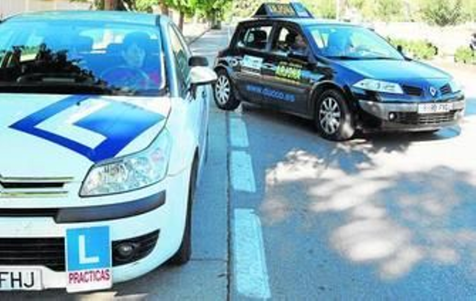Un coche de autoescuela sale a realizar sus prácticas mientras otro espera su turno en las inmediaciones de Chapín.