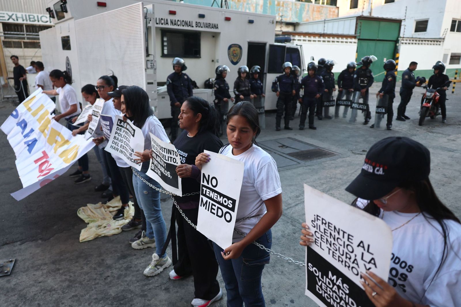 Familiares de presos políticos sostienen carteles durante una vigilia frente a la Zona 7 en Caracas.