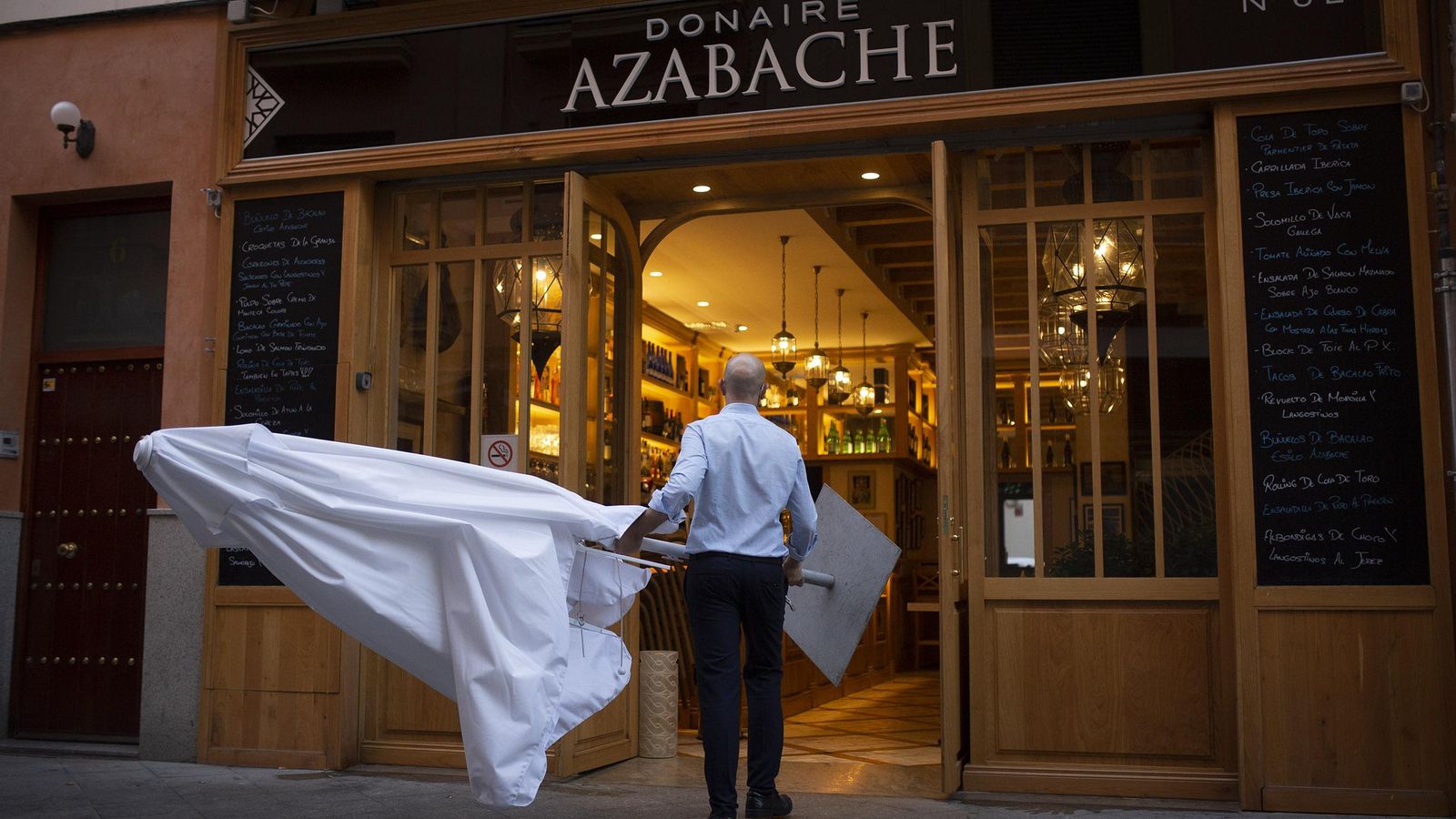 Un camarero recoge una sombrilla en el restaurante Azabache.