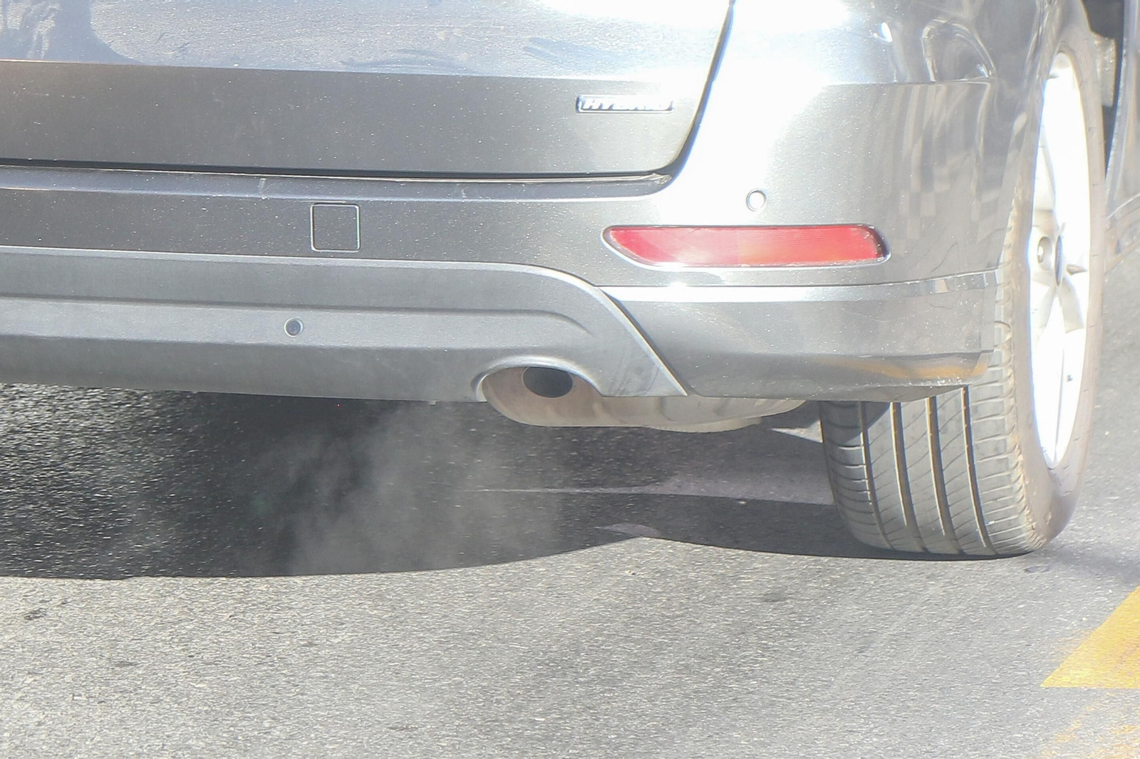 Un vehículo emitiendo gases contaminantes a su paso por Granada capital