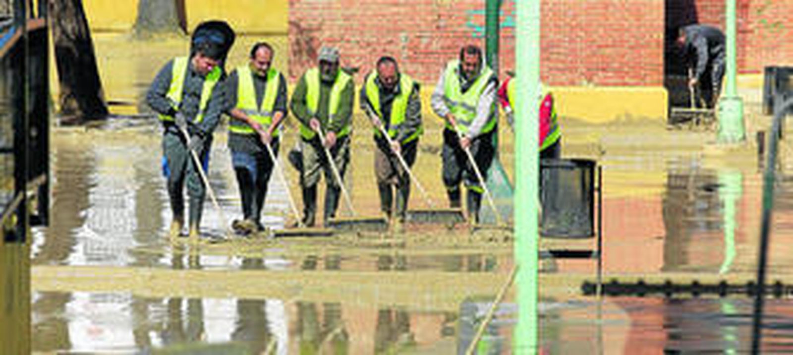 Una cuadrilla de trabajadores achica agua en un colegio de Écija.