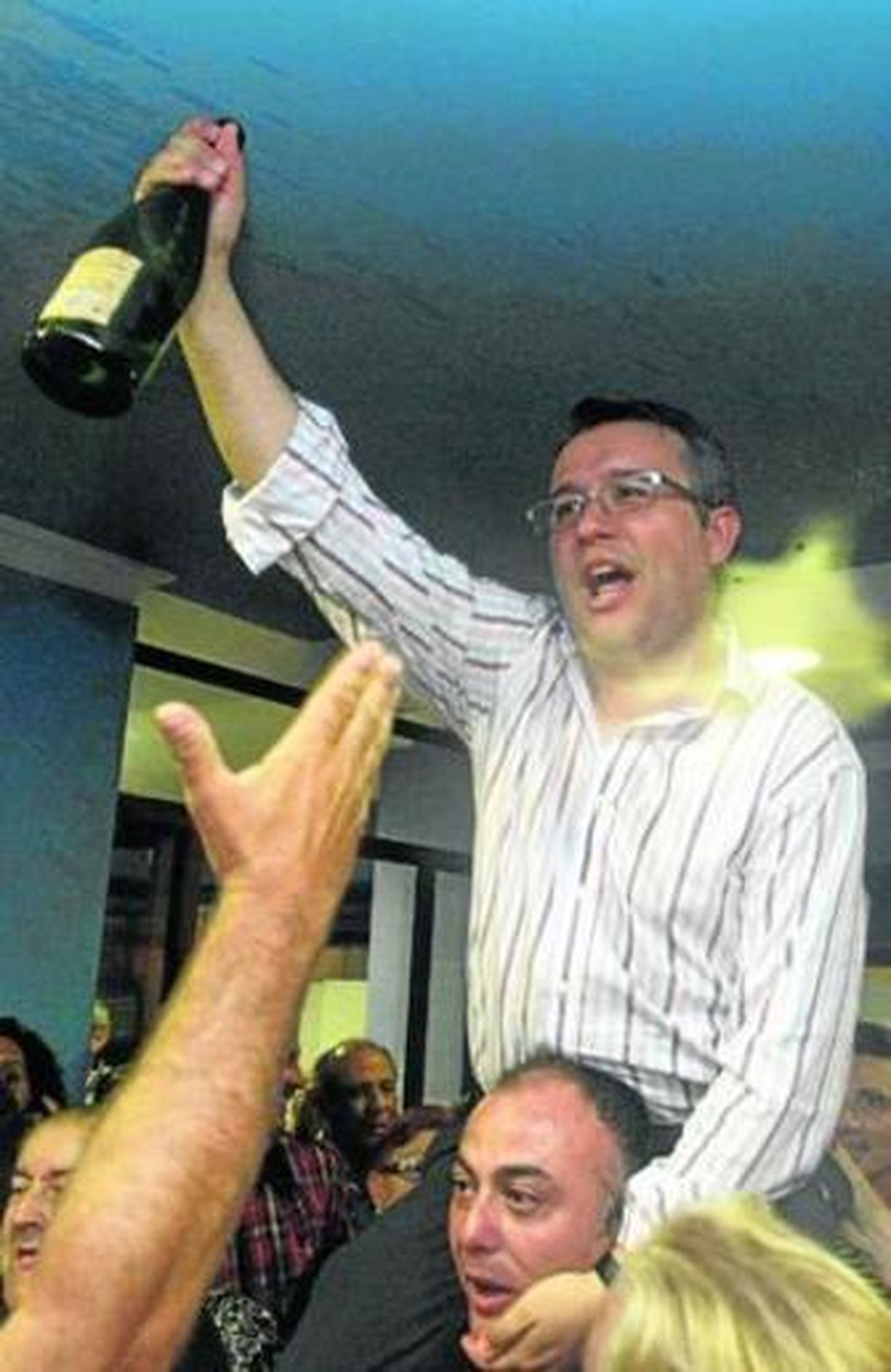 Un militante lleva a hombros a Alejandro Sánchez, con una botella de cava en la mano.