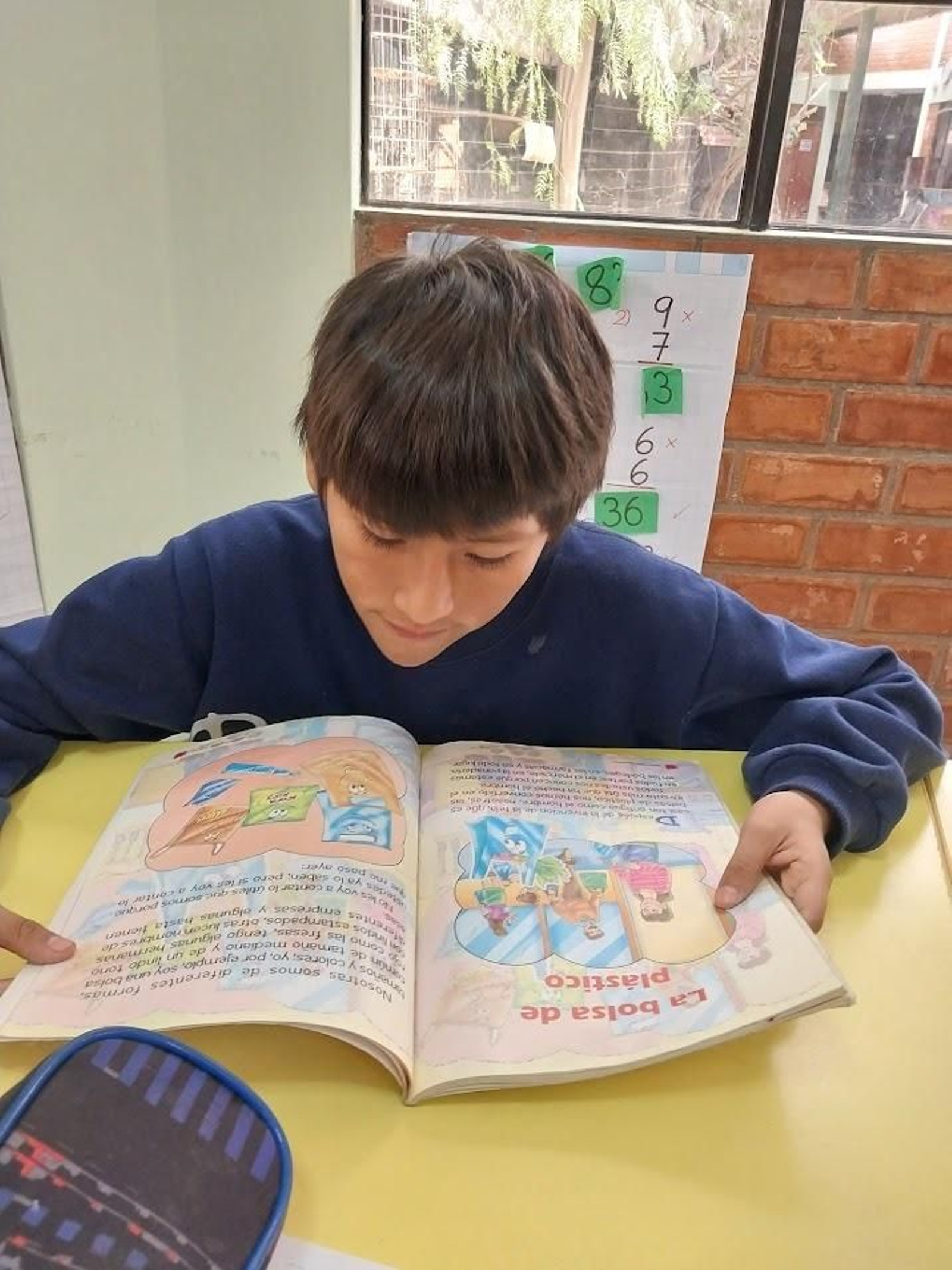 Un niño lee uno de los libros enviados por Madre Coraje.