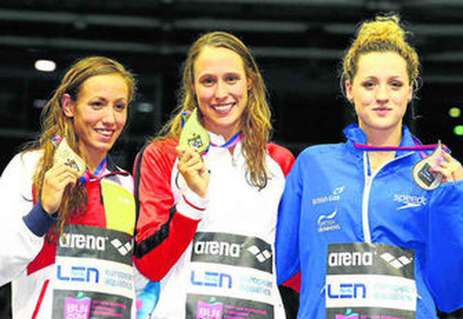 La nadadora española muestra orgullosa su medalla de bronce en el podium.